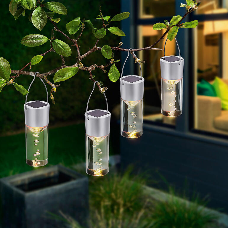 Quatre lampes suspendues LED solaires sur une branche.