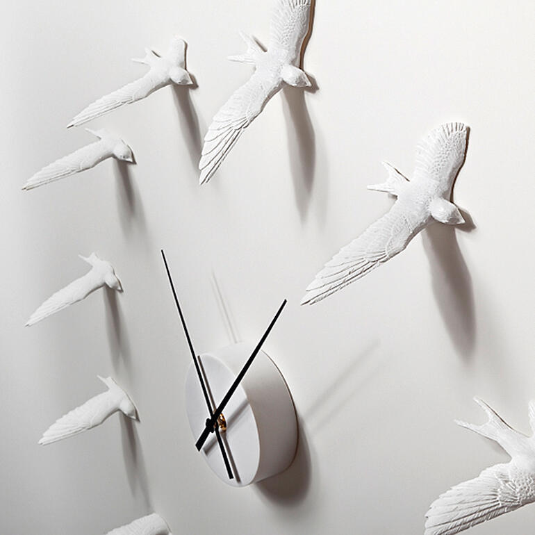 L’impression d’hirondelles vivantes est renforcée par les ombres projetées des sculptures. Gros plan de l'horloge en forme d'hirondelle, détail des ailes et du mécanisme
