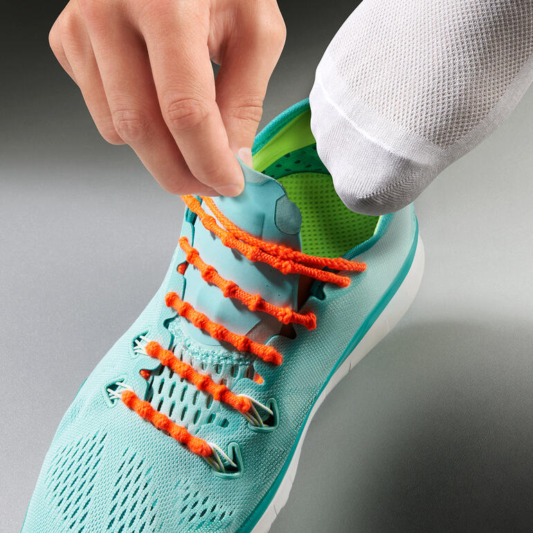 Main en train de lacer une chaussure avec le système de laçage Xtenex.