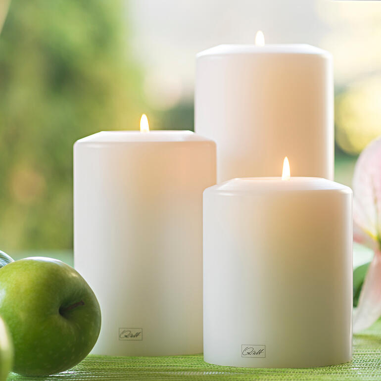 Bougie permanente Farluce Trois bougies durables blanches dans la nature entre des pommes et des fleurs