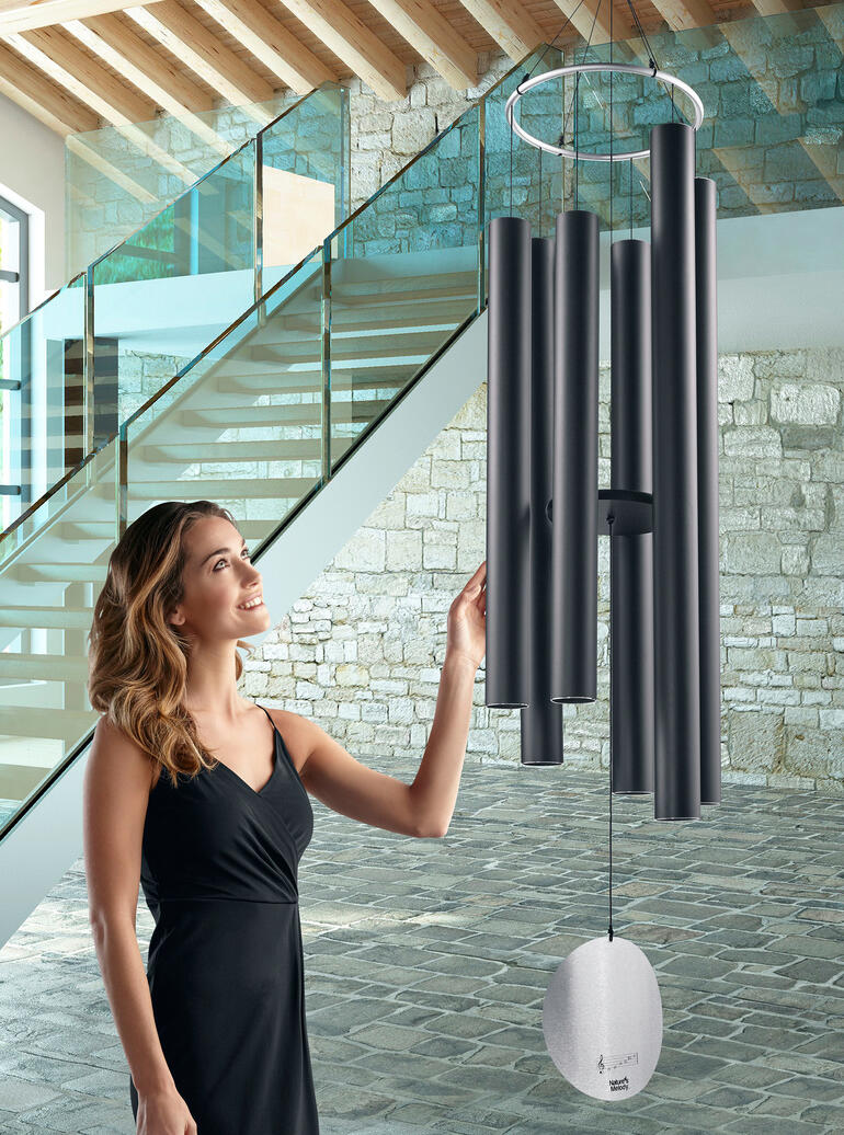 Géant carillon éolien avec plusieurs tubes dans une pièce moderne.