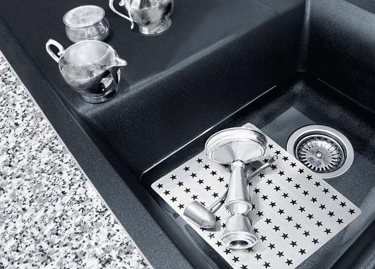 Plaque de nettoyage sur un évier avec des casseroles en acier inoxydable.