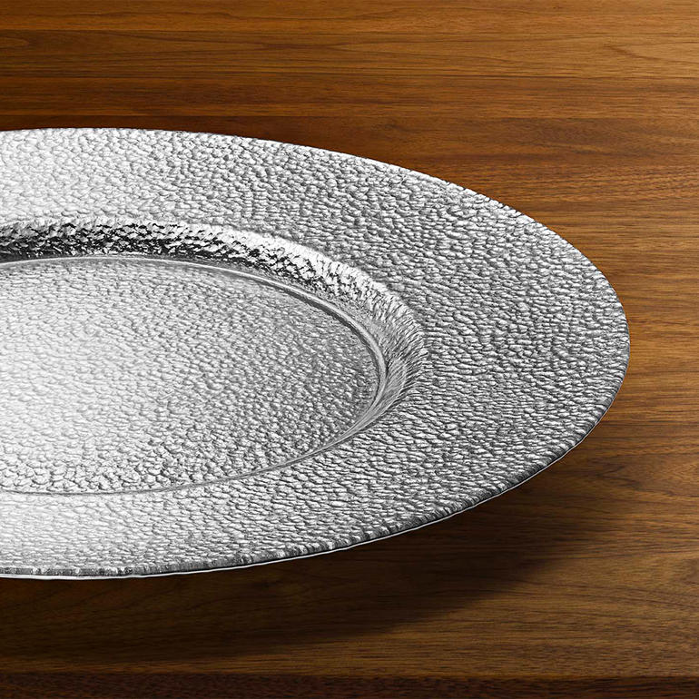 Assiette en verre argenté, élégante et décorative, sur un fond en bois.