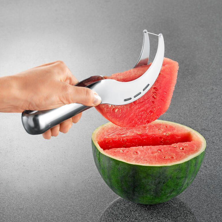Trancheur de melon Coupe-melon soulevant un morceau d'une pastèque coupée en deux.