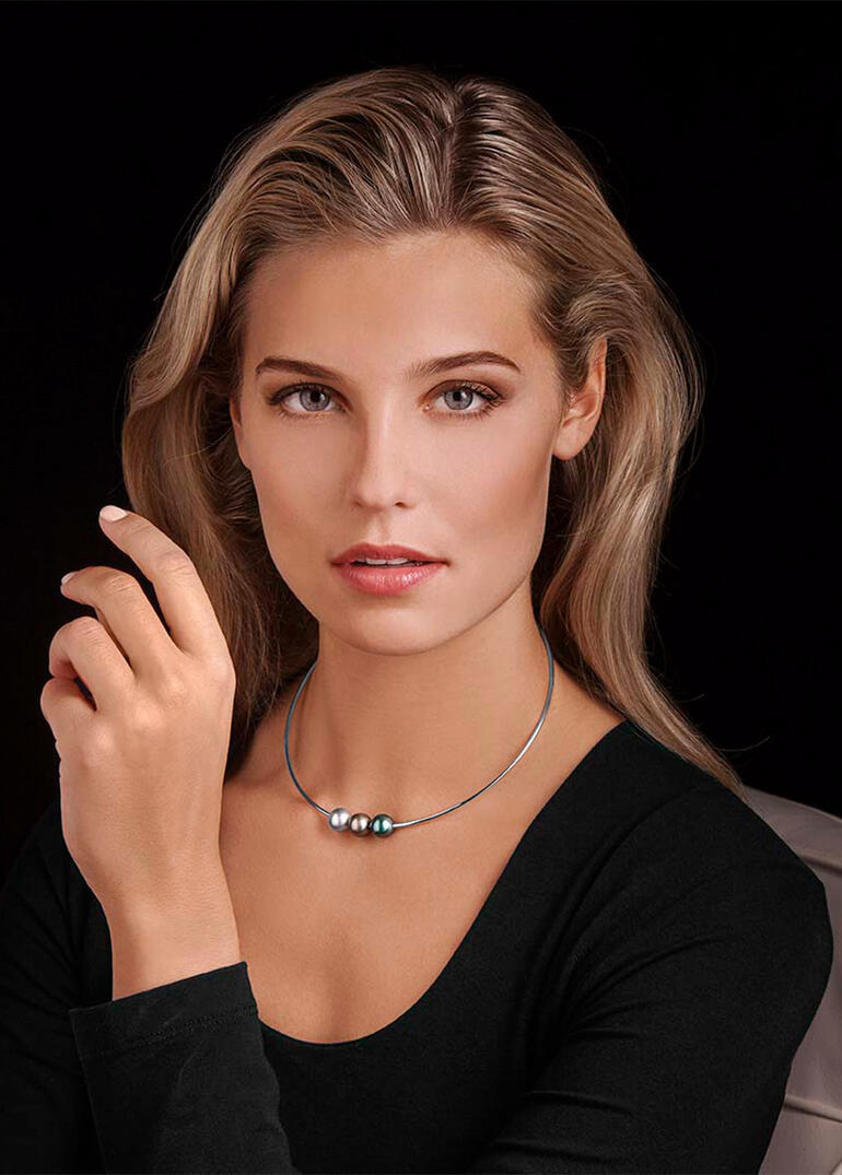 Femme portant fièrement un collier de perles de Tahiti s'approchant.