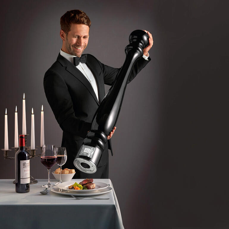 Homme avec un grand moulin à poivre en train de servir