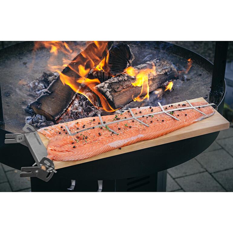 Set pour saumon fumé, planchette de remplacement incluse Filet de saumon sur une planche avec des herbes grillé au-dessus d'un feu ouvert.