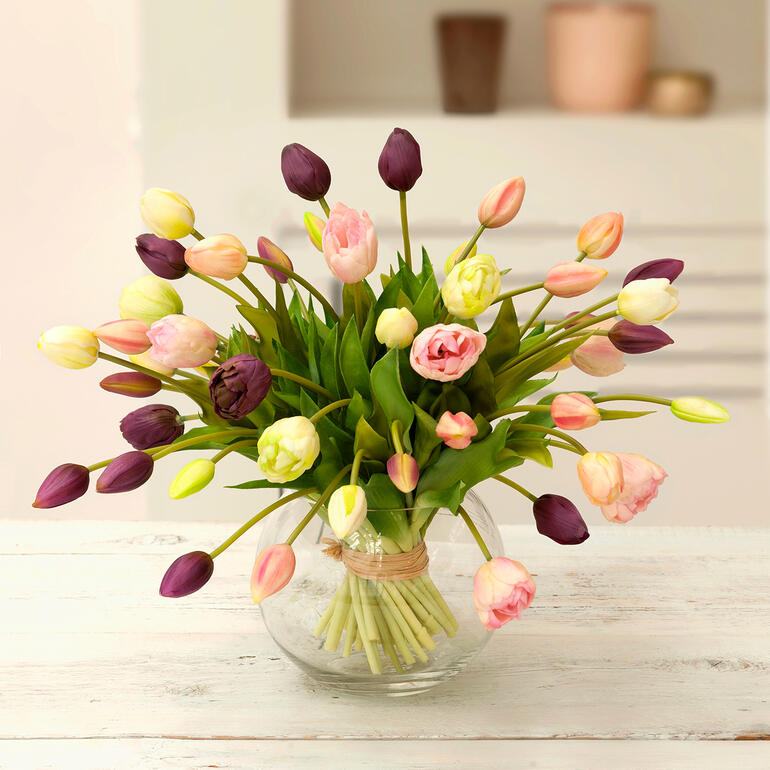 Bouquet de tulipes colorées dans un arrangement en verre.