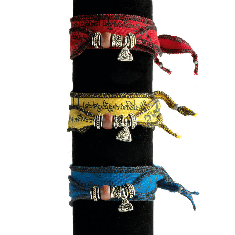 Trois bracelets tibétains de souhait en rouge, jaune et bleu avec des pendentifs en argent.