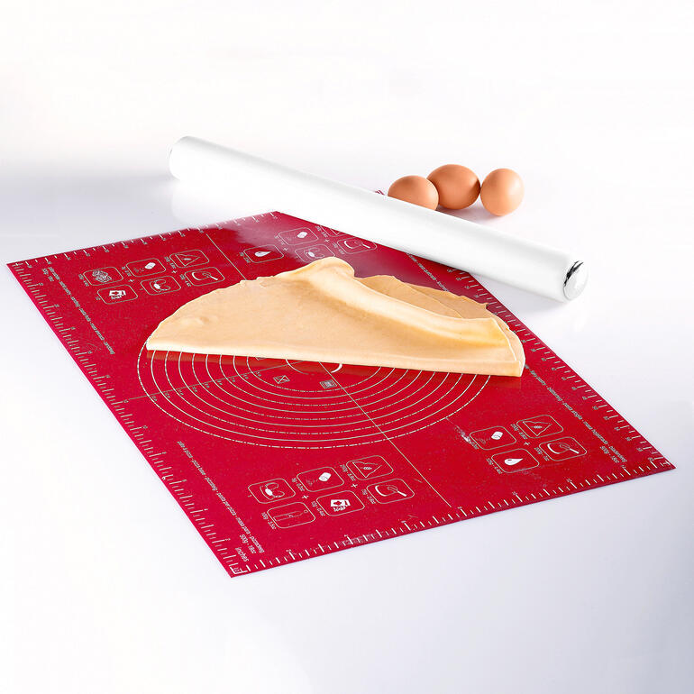 Tapis en silicone pour étaler avec de la pâte et des œufs sur fond blanc.