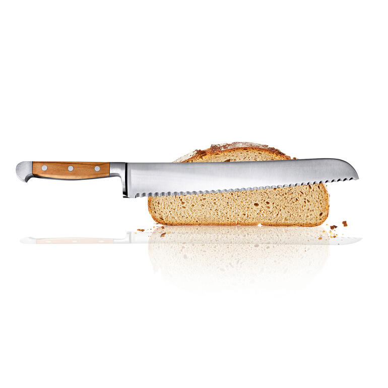 Couteau à pain avec un manche en bois et une lame dentelée à côté d'une tranche de pain.