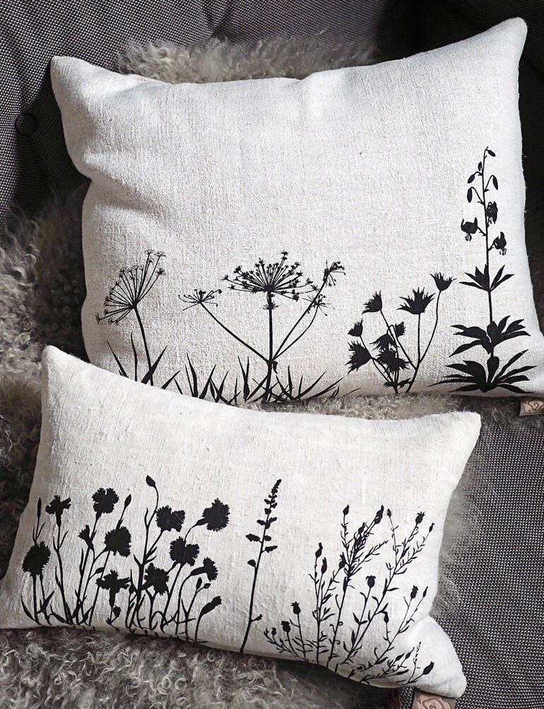 Deux coussins en lin vieux de 100 ans avec un design floral.