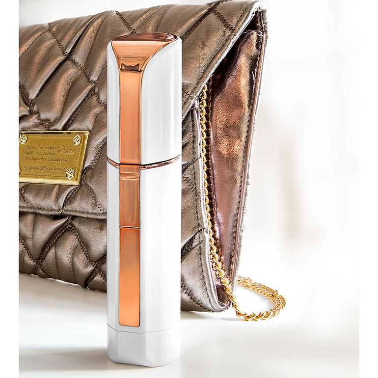 Design discret en forme de tube de rouge à lèvres, idéal pour le sac à main. Rasoir facial Roxy Pocket Shaver à côté d'un sac à main tendance.