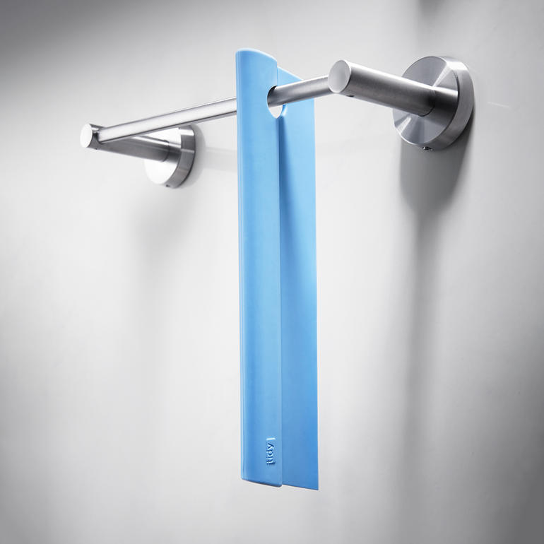Raclette de douche en silicone Raclette de douche en silicone accrochée à un porte-serviettes dans la salle de bain.
