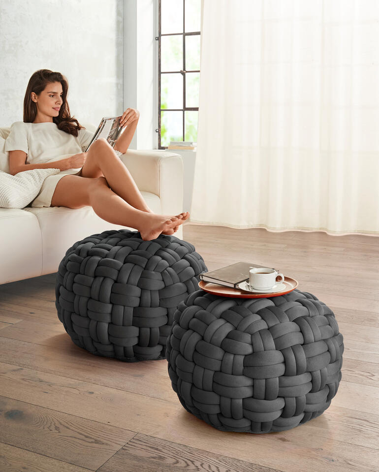 Deux poufs ronds gris en matériau tressé dans un salon