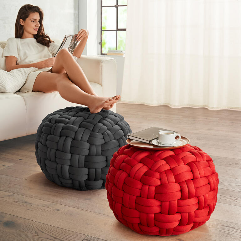Deux poufs tissés colorés en gris et rouge dans le salon.