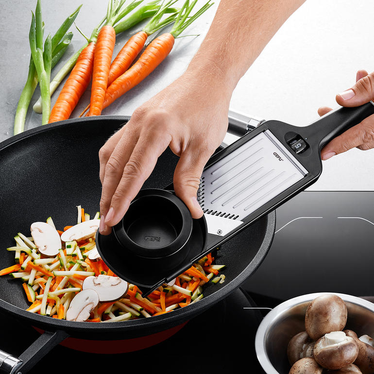 Mandoline compacte Râper des légumes avec le hachoir en V dans une poêle
