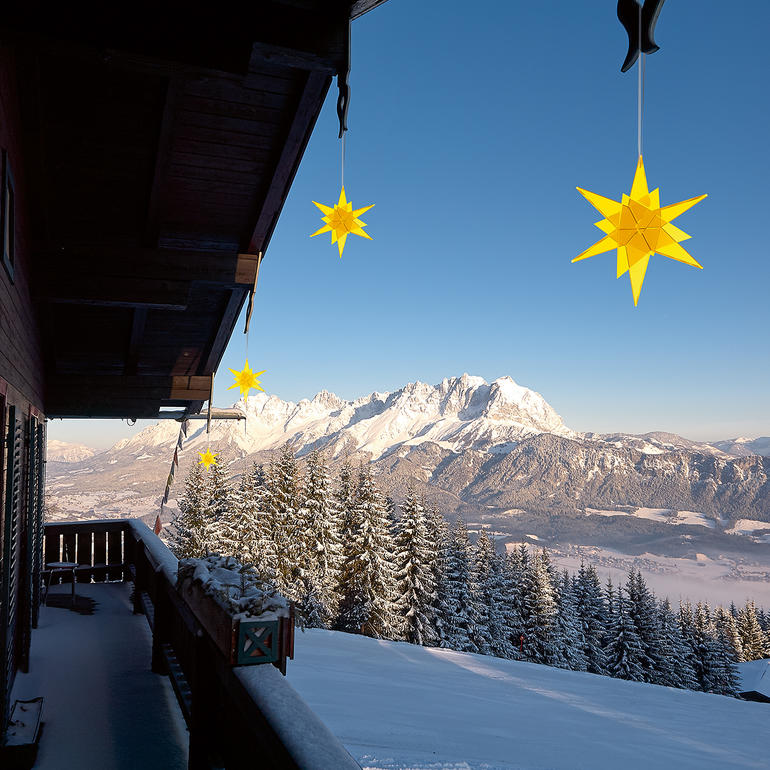 Étoiles jaunes suspendues à un balcon avec des montagnes en arrière-plan
