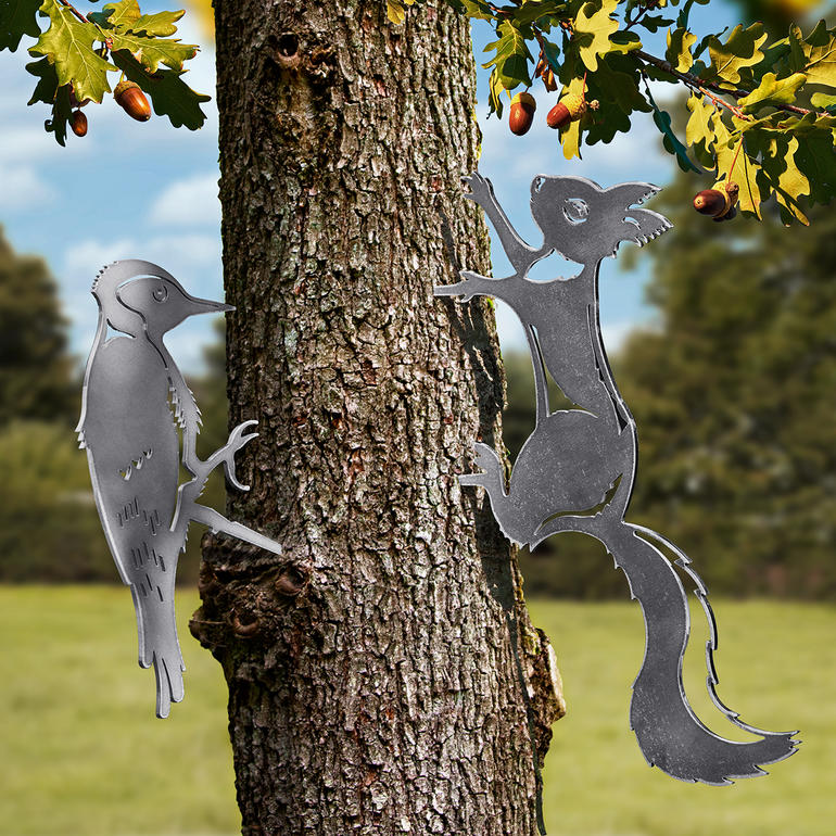 Motifs animaliers en contour métallique d'un pic et d'un écureuil sur un arbre.