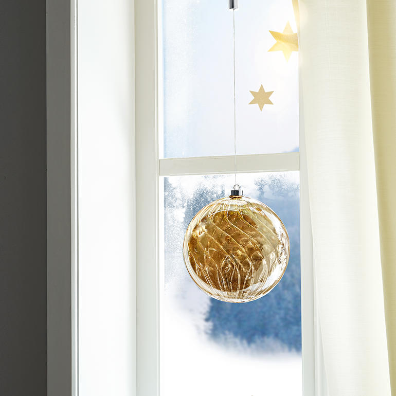 Une belle décoration à suspendre ou à poser. En journée, le verre se pare de reflets mystérieux, telle de l’ambre. Boule en verre teinté avec micro-LED suspendue à la fenêtre