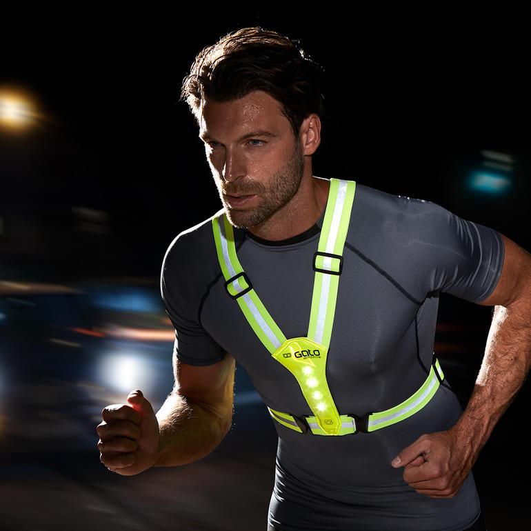 Homme portant un gilet de sécurité lumineux en courant.