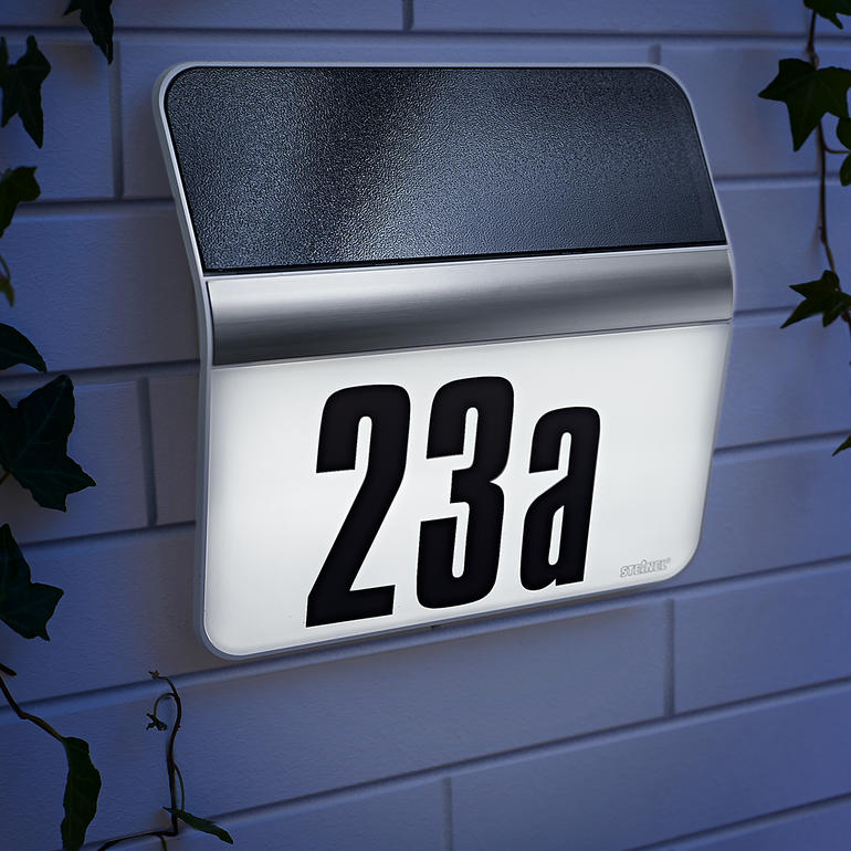 Luminaire de numéro de maison sur un mur avec le numéro 23a.