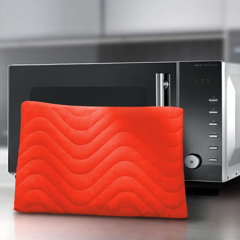 Coussin chauffant en gel au premier plan d'un micro-ondes.