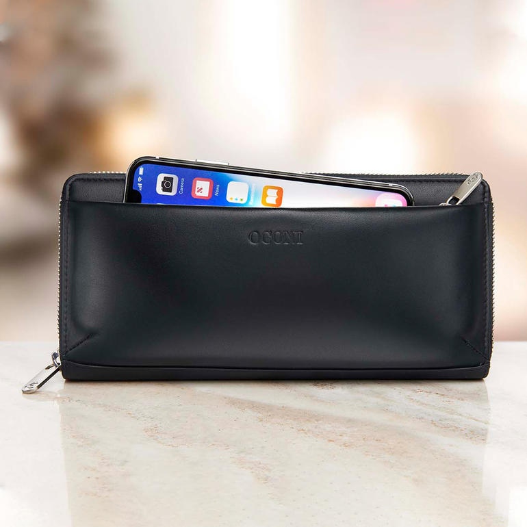 La pochette extérieure doublée et fermée par une glissière peut accueillir un smartphone. Porte-monnaie féminin noir avec smartphone à l'intérieur