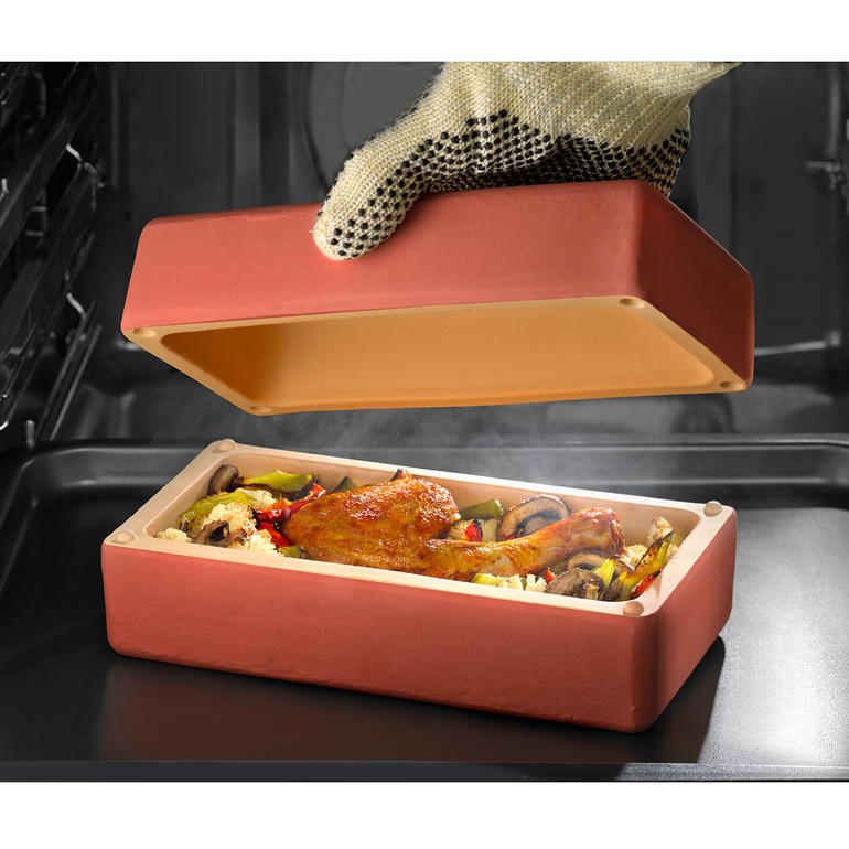 RÖMERTOPF® BBQ Brick avec une cuisse de poulet et des légumes à l'intérieur, couvercle enlevé.