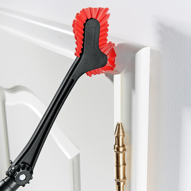 Brosse à coins et à bords nettoie le bord d'une porte.