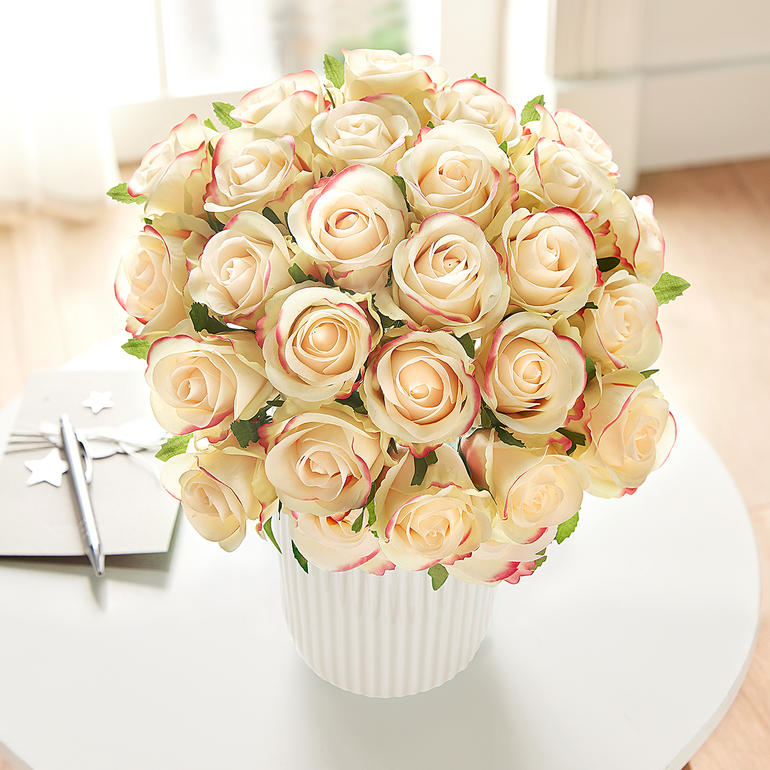 Grand bouquet de roses crème dans un pot blanc