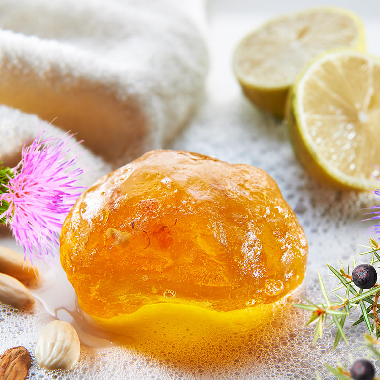 Savon d'ambre avec des agrumes et des fleurs sur une serviette.