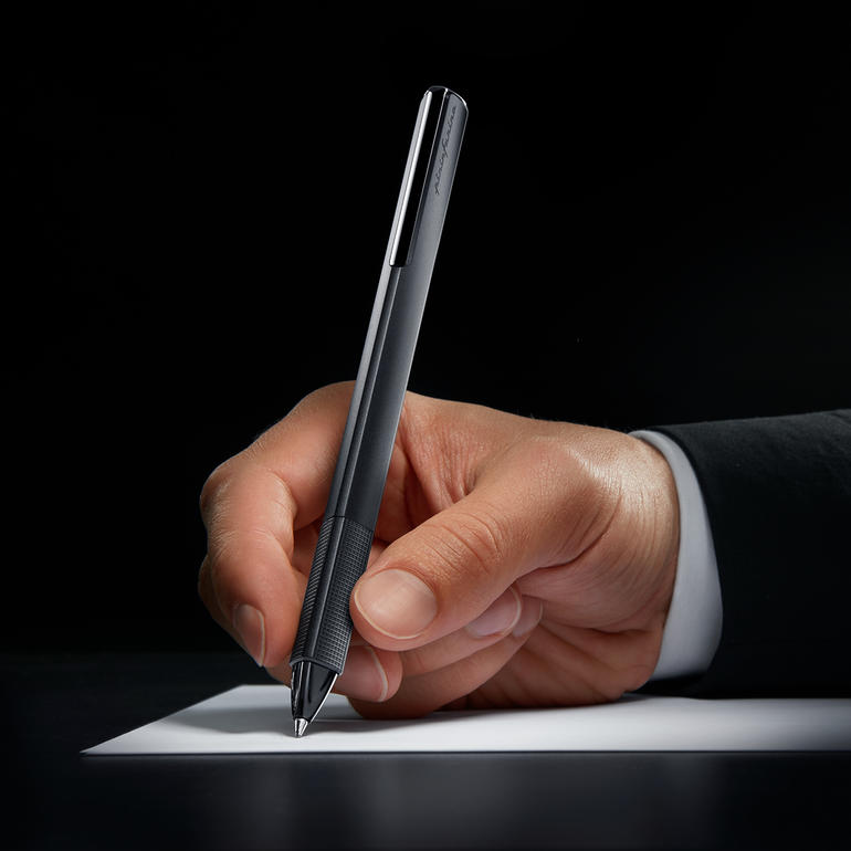 Main écrivant avec un stylo Pininfarina sur du papier blanc