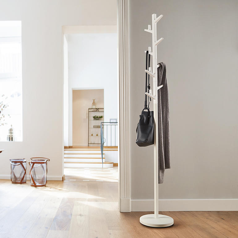 Portemanteau en branches avec un sac et une écharpe dans un intérieur moderne