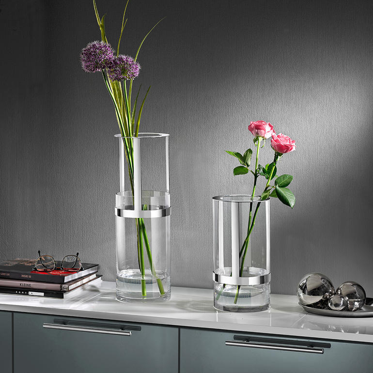 Deux vases réglables en hauteur avec des fleurs fraîches sur une table.
