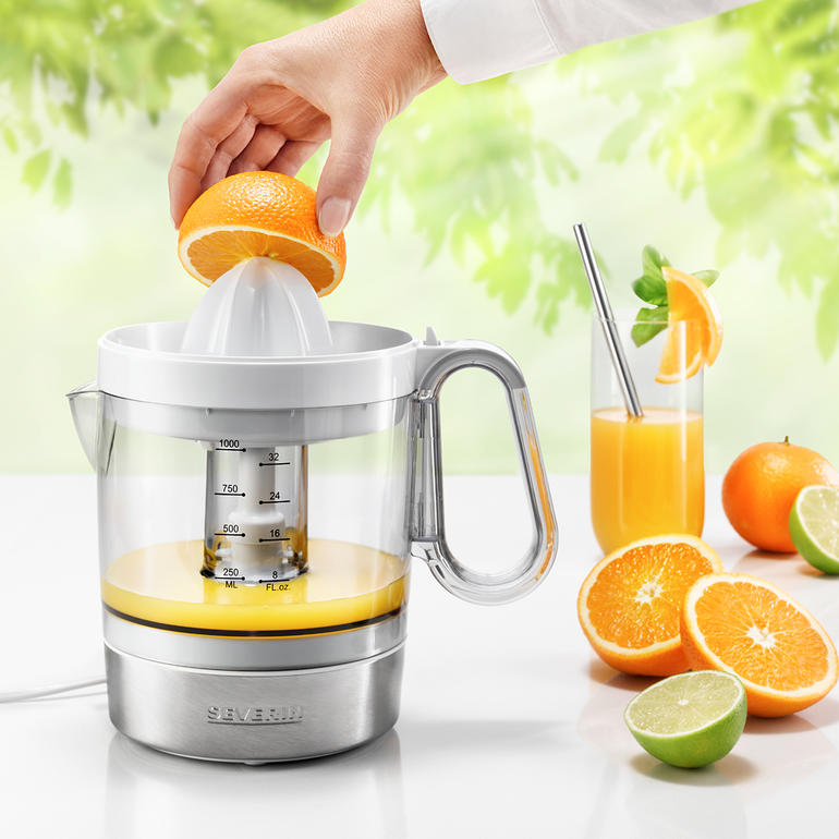 Presse-agrumes électrique avec un réservoir transparent et du jus d'orange fraîchement pressé.