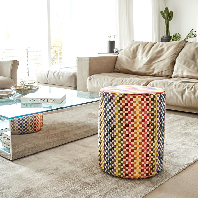 Pouf coloré Missoni à côté d'un canapé confortable dans le salon.