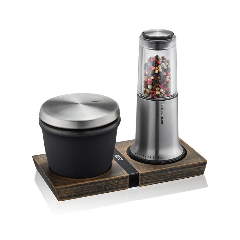 Moulin à poivre et sel ou Boîte à épices X-Plosion® Moulin à poivre/sale X-Plosion avec récipient noir et moulin transparent sur un sous-plat en bois.