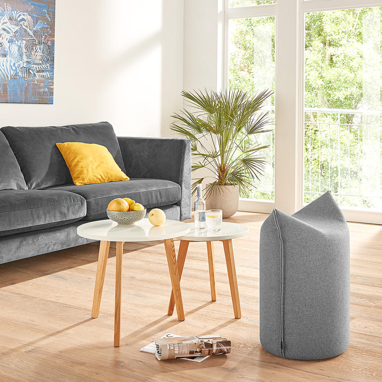 Pouf en gris dans le salon avec canapé et table.