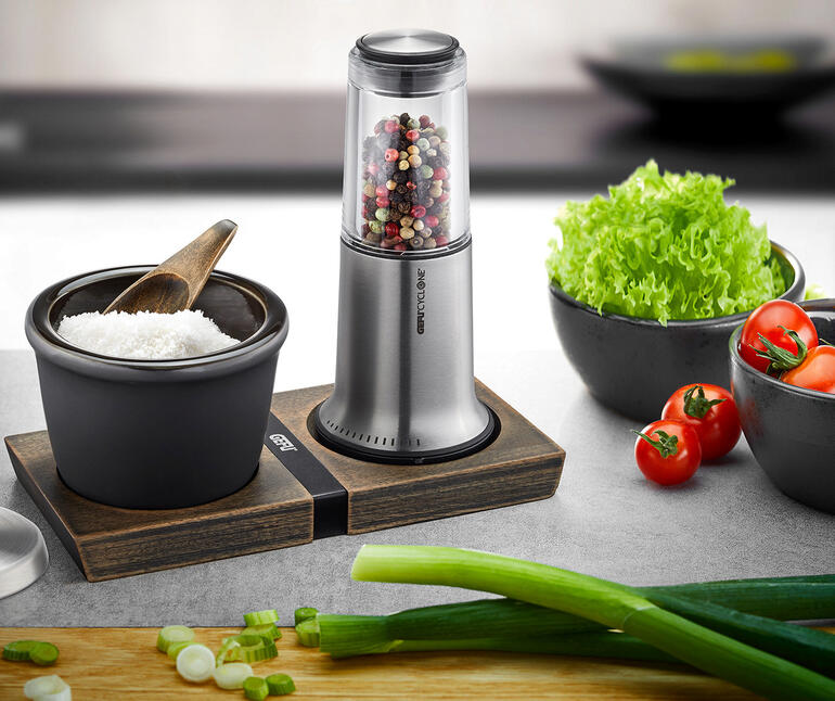 Moulin à poivre/sel X-Plosion® sur une table avec des légumes.