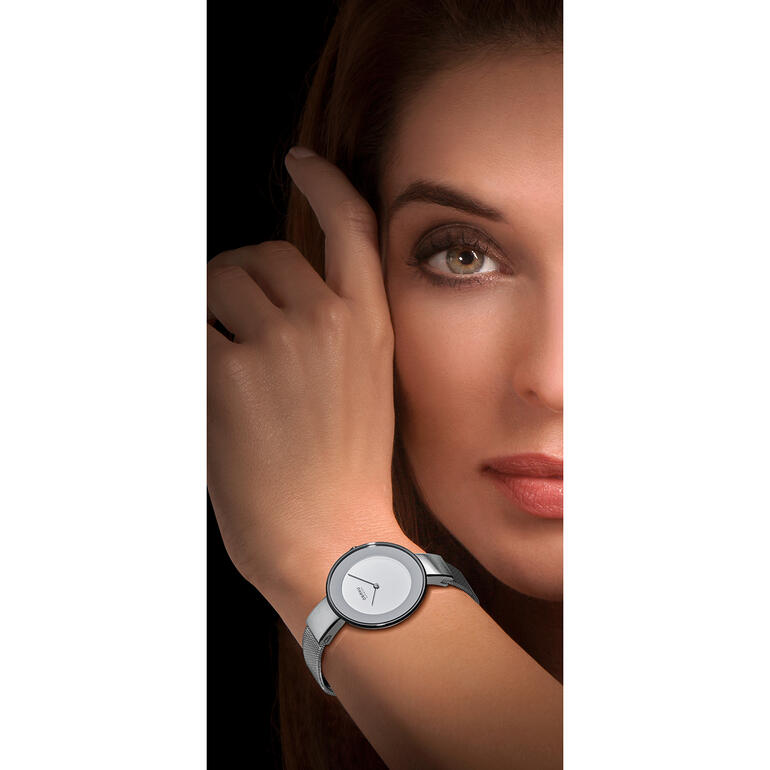Femme portant une montre bracelet milanaise regardant la caméra.