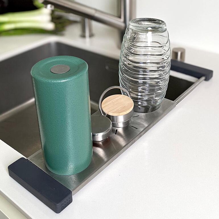 Support de lavage avec des conteneurs sur la surface, juste à côté de l'évier.