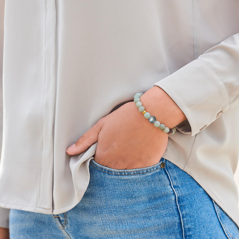 L’élégant bracelet de grande qualité se combine avec tous les styles vestimentaires, à tout moment de la journée. Gros plan d'un bracelet en amazonite au poignet d'une femme