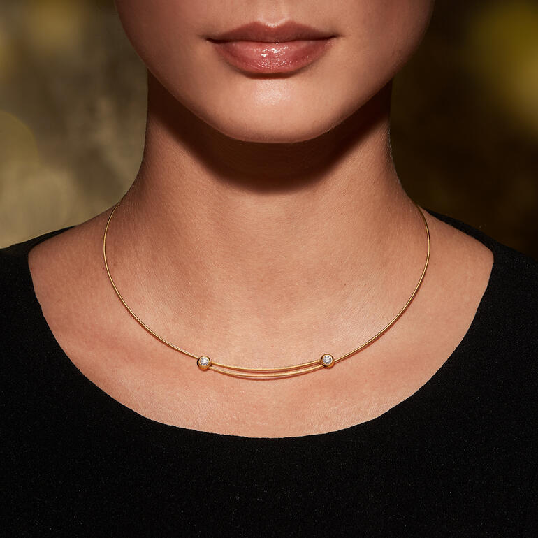 Femme portant un collier en câble doré avec des diamants