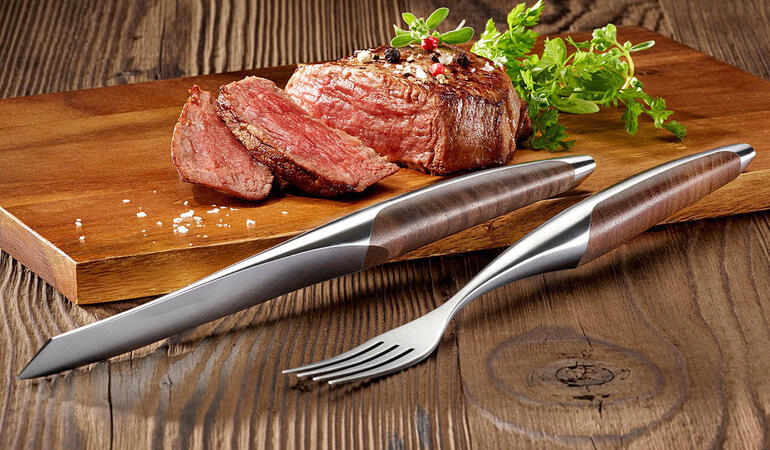 Ensemble de couteau et fourchette à steak servi avec un steak.