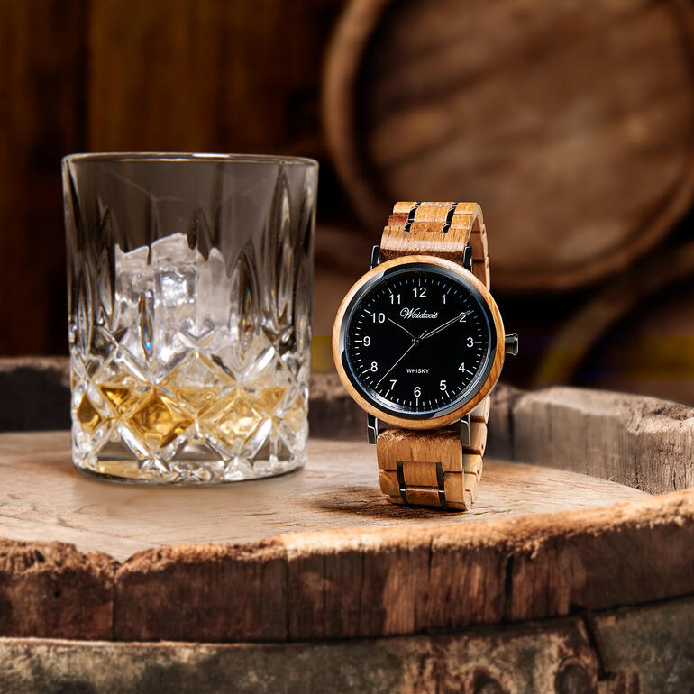 Montre pour homme en fût de whisky à côté d'un verre de whisky