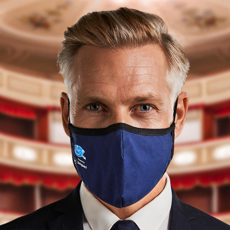 Homme en costume noir portant un masque bleu