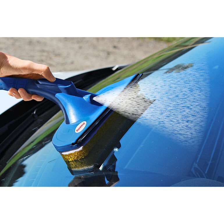 Main utilisant insecto spray-wiper pour nettoyer le pare-brise.