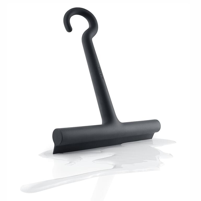 Raclette de douche en silicone design sur une surface blanche avec des gouttes d'eau.