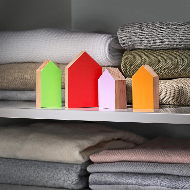 Maisons en cire colorées de différentes formes sur une étagère.